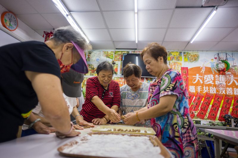 台北市北投清江里十多位女性長輩正跟著老師製作麻花捲。高齡人口中女性人數較多，活動現場也經常可見女性長輩踴躍參與。（攝影／黃世澤）