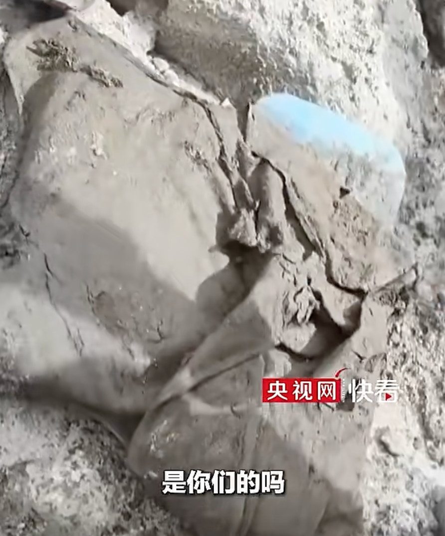 西藏泥石流|瘀泥中现警用背心 警察认领时声沙:这肯定是我们的 2 吉隆口岸一線的救援人員在現場搜尋失聯人員物品,將搜尋到的一件衣服交給現場警察辨認。
