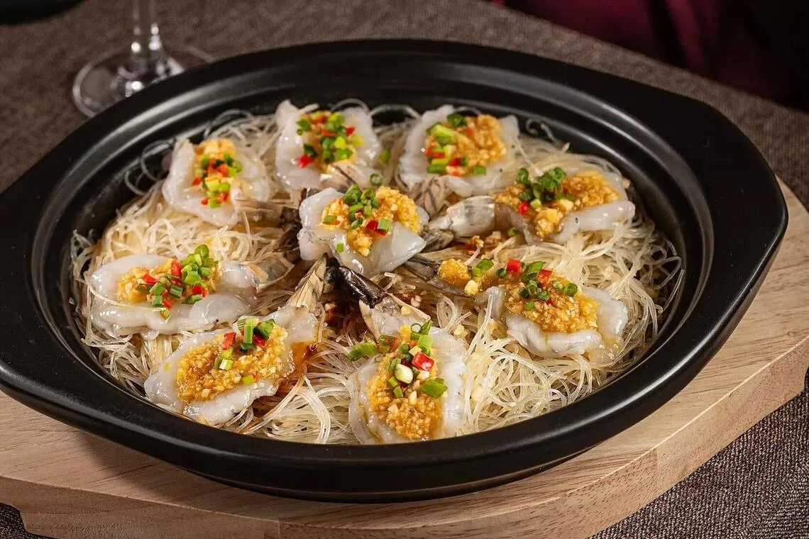 韭香蒜蓉大虾煲的虾肉吸足蒜香与酱汁鲜味。（餐馆提供）