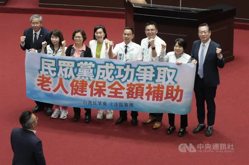 立法院三读通过老人福利法第22条修正后，民众党团成员在议场举标语庆祝。