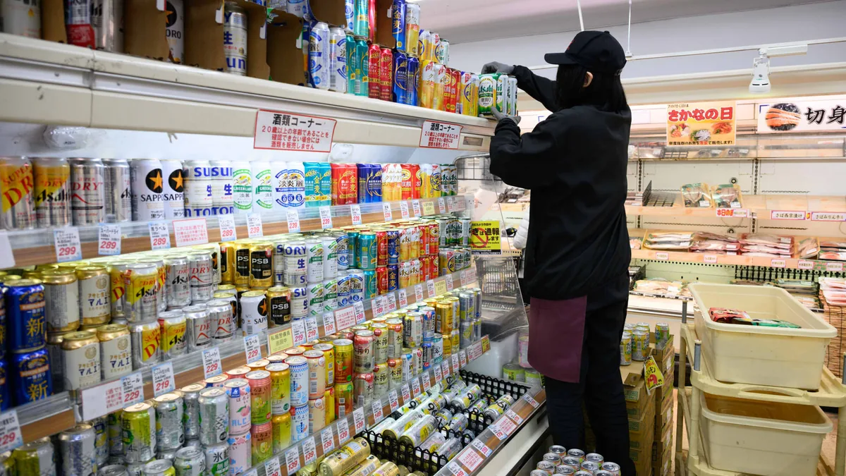 日本横滨一家超市的工作人员整理饮料货架(资料图片)