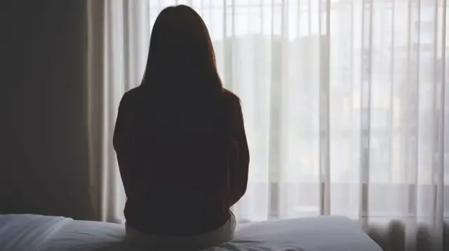 一名坐在床上的女子资料照