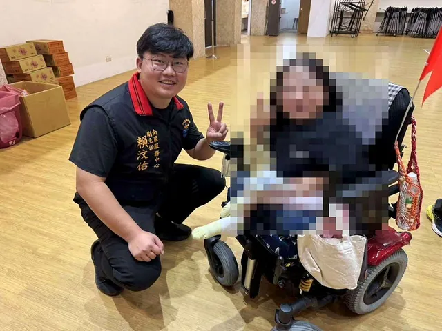 赖汶佑（左）在室内与一名民众合影。