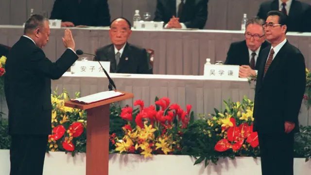 香港会议展览中心内董建华（左）在李鹏（右）面前宣誓就职（01/07/1997）
