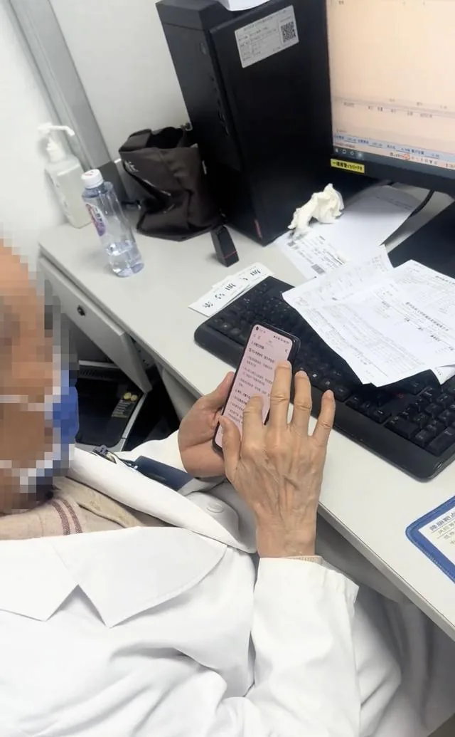 医生在诊桌前操作手机（来源视频画面）