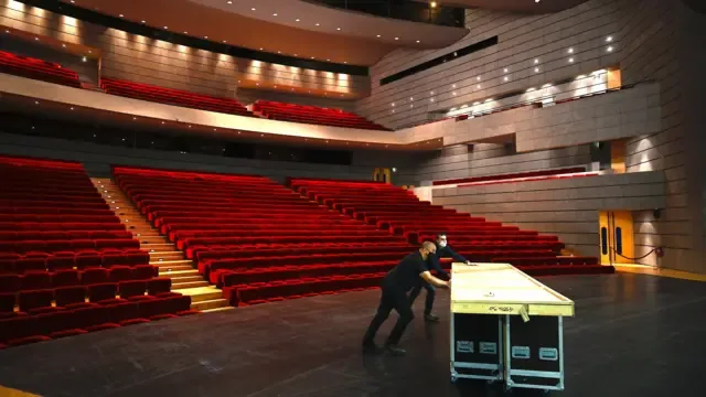 法国米卢斯一座剧院内后台工作人员在搬运器材与布景板（资料图片）