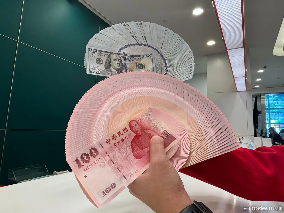一叠新台币百元钞票，后面是一叠美元百元钞票