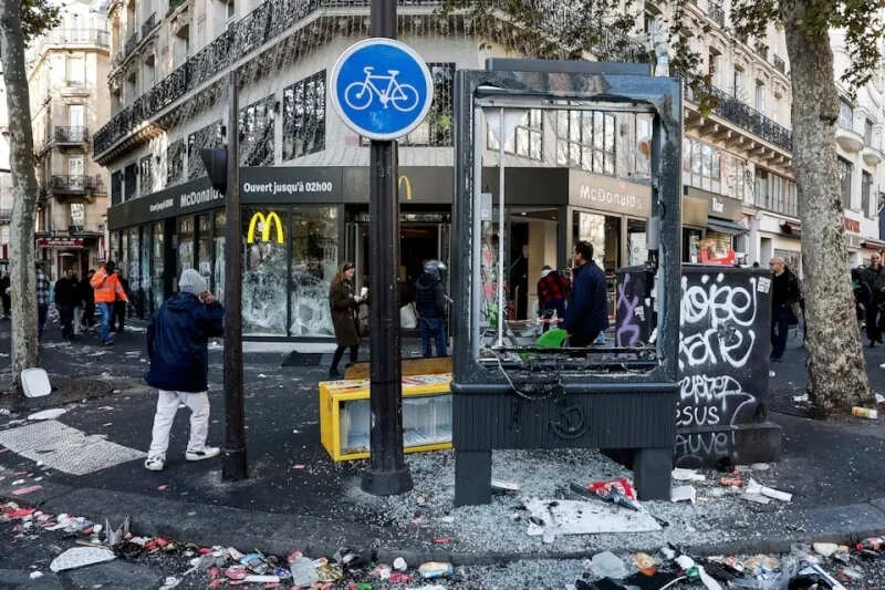 法國示威潮釀成暴力事件，巴黎街頭18日可見麥當勞等商家玻璃遭破壞受損。（路透社）