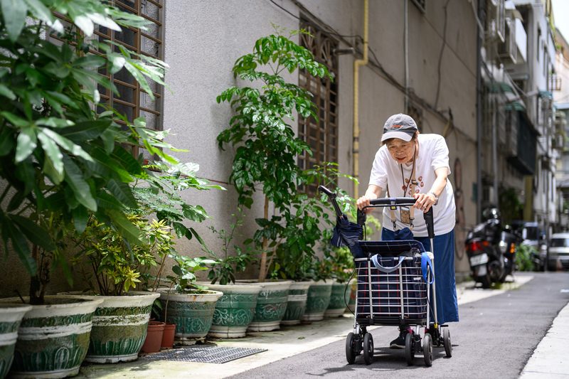 73歲羅阿月獨居在台北市一棟老公寓的4樓，雖有女兒但關係疏遠。里長舉辦的活動減少了她的孤獨感，但她仍擔心獨自在家跌倒，無人察覺。（攝影／黃世澤）