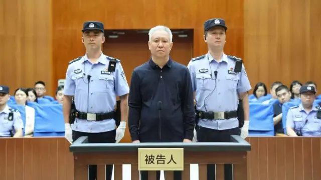 许家印（中）在法警押送下，于中国广东深圳市中级法院出庭（深圳中级法院图片20/8/2026）
