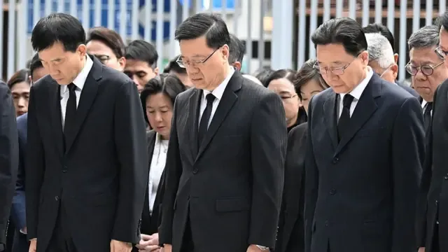 2025年11月29日，香港行政长官李家超（中）及其他北京与香港政府官员在香港政府总部默哀三分钟，悼念宏福苑火灾的罹难者。 