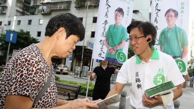 区锦新自1993年起踏足政界，图为2013年他在立法会选举期间接触市民