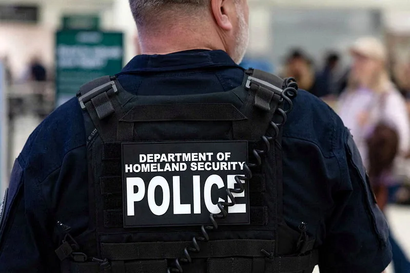 身穿国土安全部警用背心的执法人员背影，来源报道所用资料照片