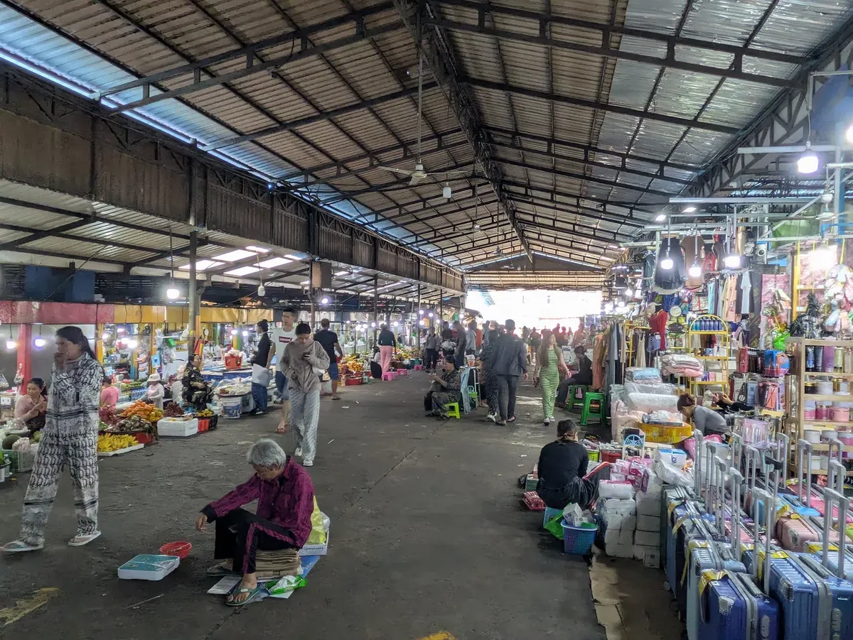沙乐市场内一排排摊位密集排列，生鲜食材、蔬果鲜花、厨具、电器、服饰、祭拜用品，应有尽有。（黄匡宁摄）