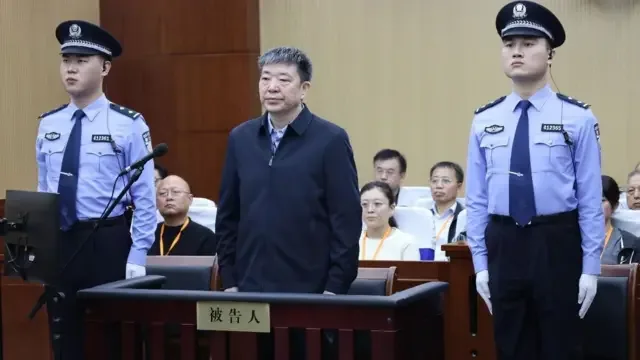 周先旺（中）在警员押送下于河南商丘中级法院出庭（商丘中院商丘天秤之声图片10/10/2026）