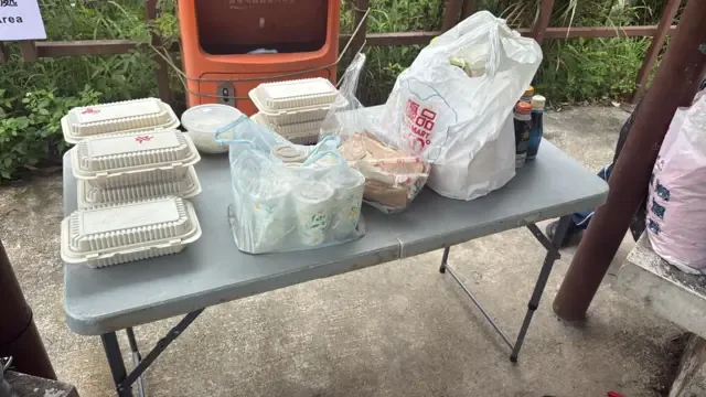 在一个剧组里，一张桌子上放满饭盒