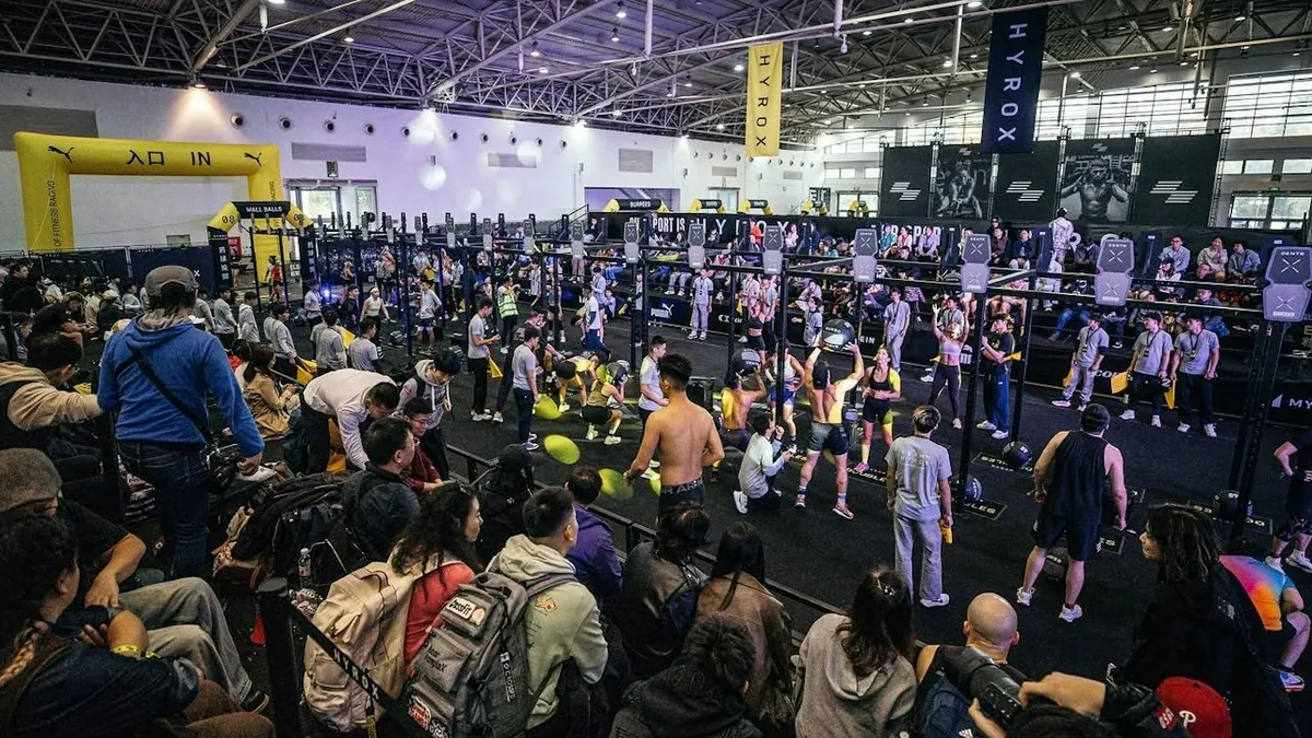 HYROX体能竞速赛在展馆里举行，选手在场上比赛，观众在场边观看