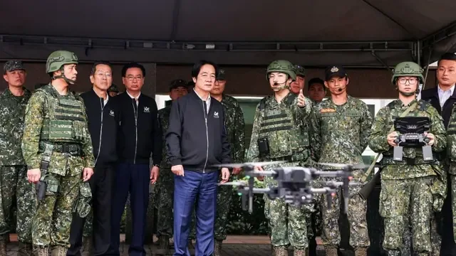  2025 年 12 月 2 日，台湾宜兰县，台湾总统赖清德（中）在龙德兼利泽产业园区服务中心视察教育召集训练，观看后备军人操作 Hummer 2（悍马 2 型）无人机。