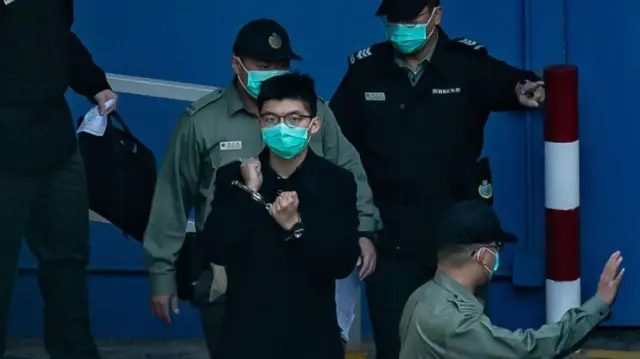 2020年12月18日，在香港荔枝角，民主派活动人士黄之锋准备登上惩教署的车辆，前往参加庭审。