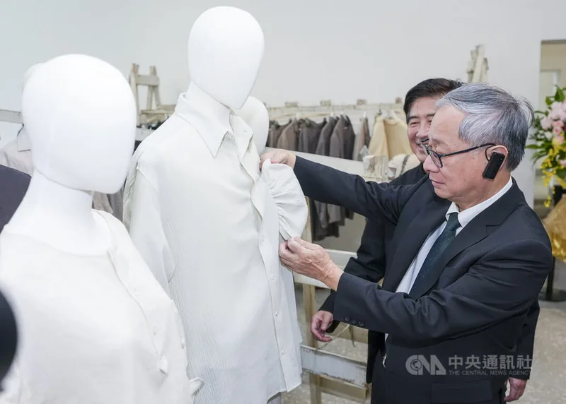 「台北時裝週SS27」15日在空總國家文化基地登場，文化部長李遠（右）參觀品牌服裝展示空間，仔細觀察服裝材質與設計細節。中央社記者鄭清元攝　115年10月15日