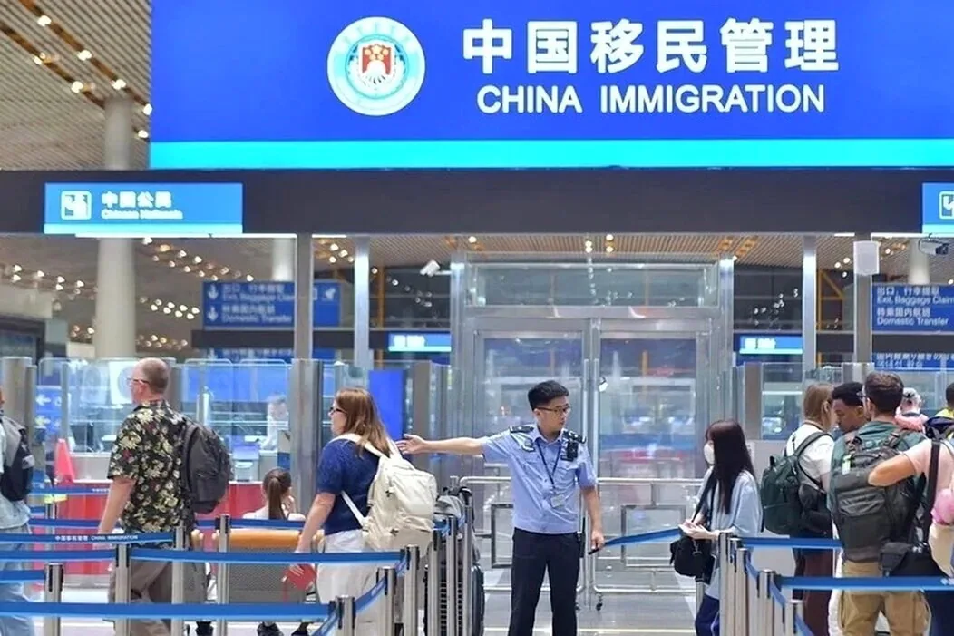 旅客在标有“中国移民管理”的通道前等候（资料照片）