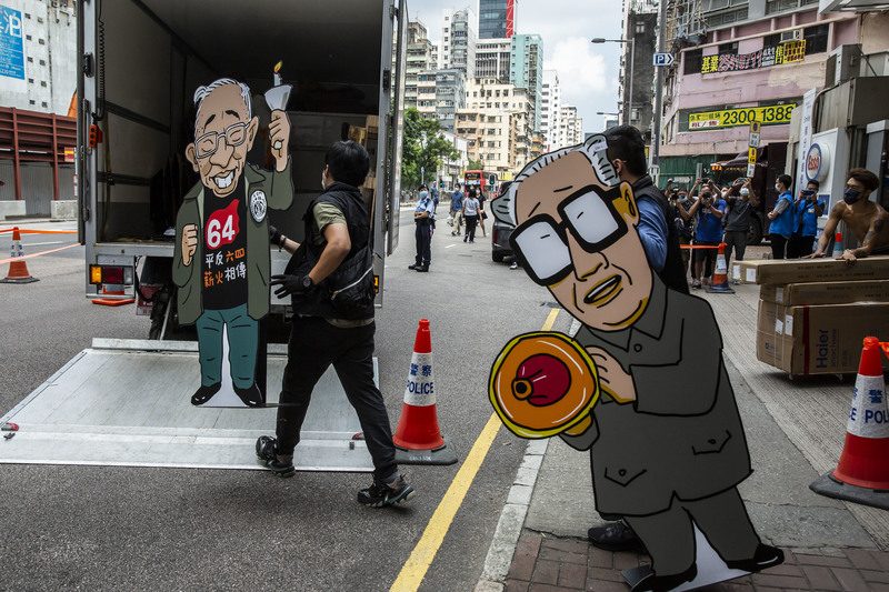 2021年9月9日，香港國安警察破門搜查由支聯會經營的六四紀念館，並帶走繪有司徒華（左）呼籲平反六四，以及前中共總書記趙紫陽在北京戒嚴前夕親赴天安門廣場探視絕食學生的漫畫看板。（攝影／Isaac Lawrence／AFP）