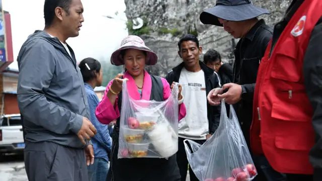 西藏日喀则市吉隆县吉隆镇吉甫村安置点，志愿者为受灾民众发放盒饭（中新社图片29/8/2026）