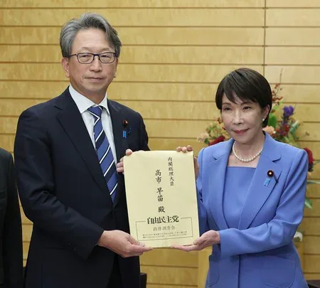 高市早苗(右)在首相官邸接过平将明的网络安全建议书,10月23日