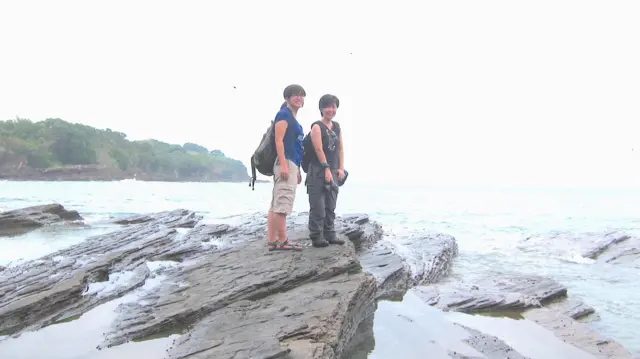 邹幸彤与刘家仪在东平洲岩石上拍照。
