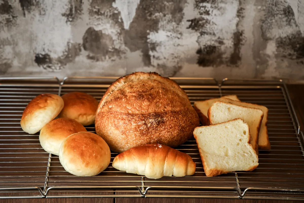 田Bakehouse原味酸种面包（中）、日式吐司（右）、日式盐面包（前），以及日式吐司面团做成的小圆面包，深受欢迎。（叶振忠摄）