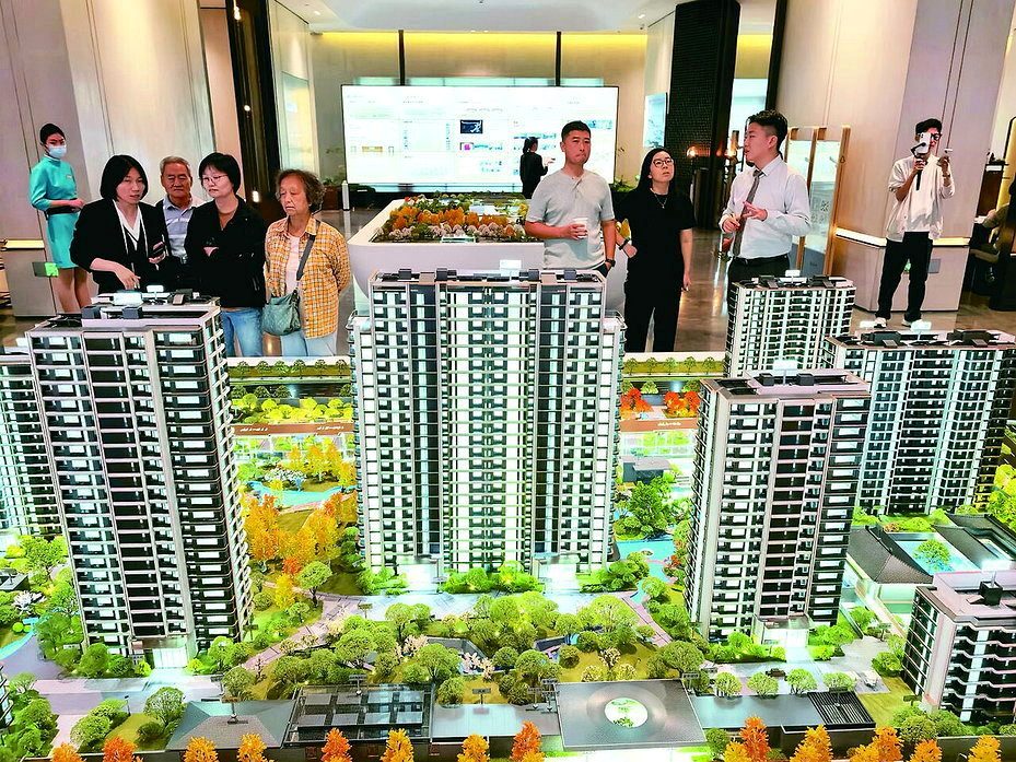购房者在售楼处看楼盘模型