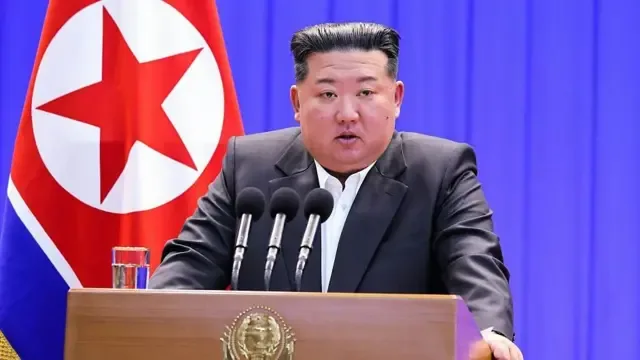这张照片拍摄于2026年2月2日，由朝鲜官方通讯社朝中社（KCNA）透过朝鲜通信社（KNS）于2026年2月3日发布。照片显示，朝鲜领导人金正恩在朝鲜国旗的背景下发表演说。