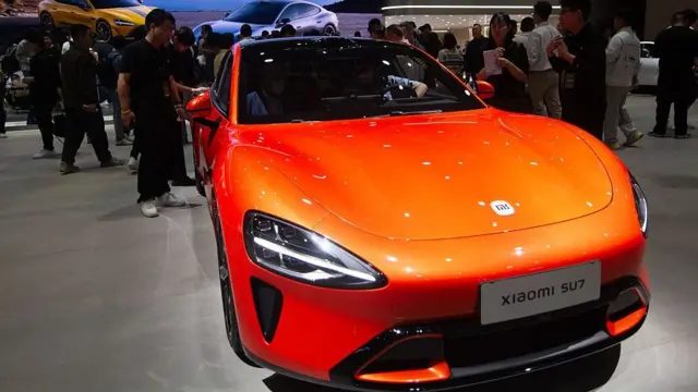 2025年4月，中国上海国家会展中心的小米摊位上展出一辆亮橘色的小米SU7车。