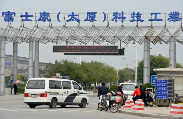 2012年9月24日，中国山西省太原市，一辆警车驶向富士康科技工业园区入口。由于前一晚员工宿舍内一宗个人纠纷演变成涉及2,000名工人的斗殴事件，造成40人受伤，台湾富士康科技集团于周一关闭其位于中国北部太原的工厂。