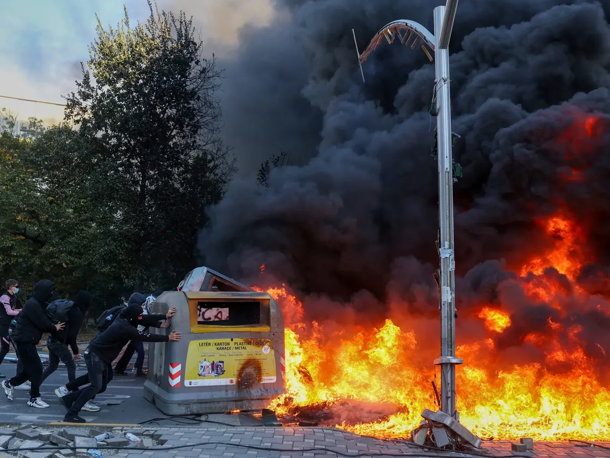 地拉那市中心，抗议者在和警察冲突时点燃垃圾桶
