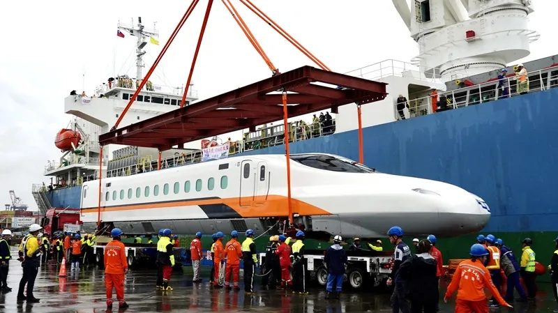 台灣高鐵N700ST全新車型抵台（3） 台灣高鐵首組N700ST列車15日抵台，率先亮相的車頭在雨中從船艙順利降置在碼頭邊的拖車上，宣告N700ST自即日起正式在台灣落地生根。中央社記者董俊志攝115年8月15日
