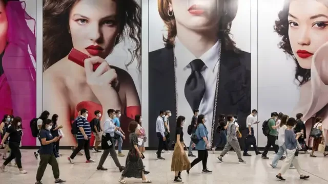 2021年10月6日，通勤者走过香港中环地铁站内华伦天奴的大幅广告。