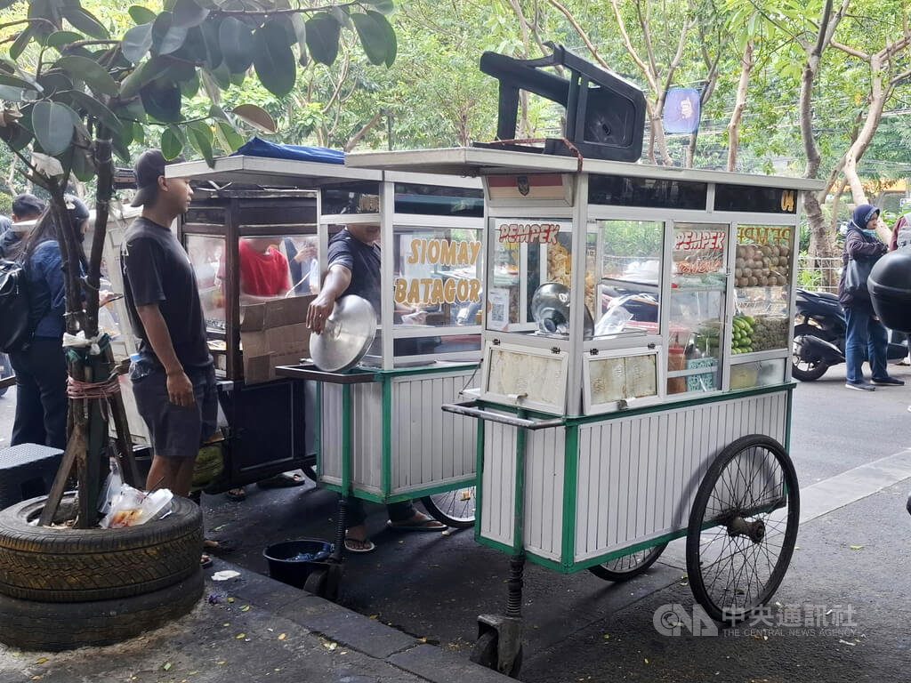 雅加达街边的小吃推车,玻璃柜上贴着QRIS支付码
