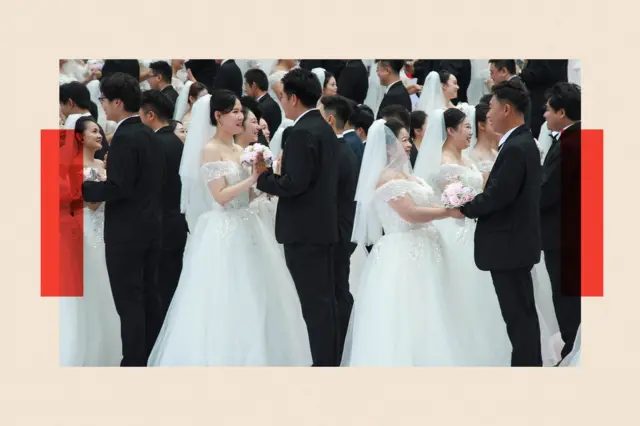 身穿蓬松白色婚纱的新娘与身穿黑色西装的新郎参加集体婚礼。