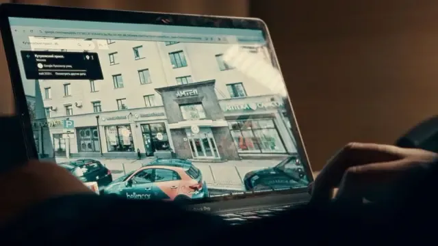 福马的电脑萤幕上显示俄罗斯境内的建筑物和车辆，而他的手正放在电脑键盘上。