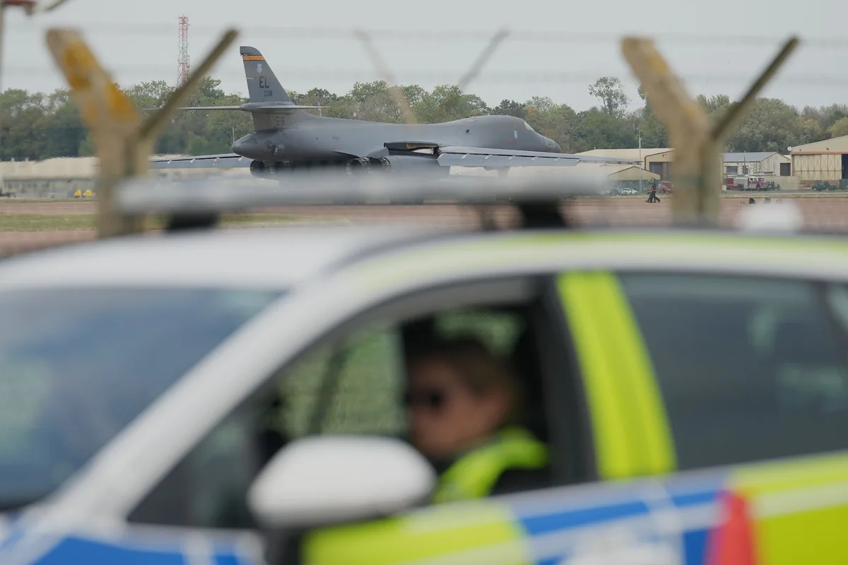 9月29日,警车停在英国费尔福德空军基地附近,后方可见一架轰炸机。