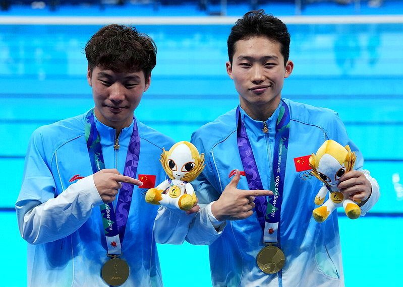 愛知·名古屋亞運會跳水項目男子雙人3米跳板決賽26日在東京水上運動中心舉行。冠軍中國選手王宗源（右）/鄭九源在頒獎儀式後。（新華社）