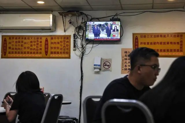 2026年9月25日，台北一家餐厅的顾客正在用餐，电视上播放美国总统特朗普与中国国家主席习近平会晤的新闻。 