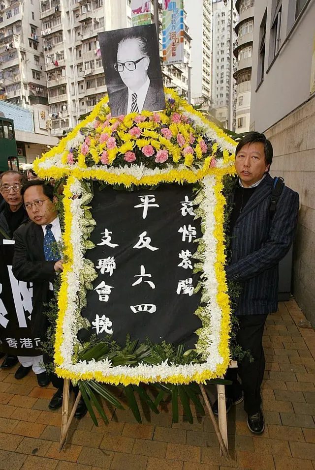 2005年1月17日，中共前总书记赵紫阳逝世。翌日，何俊仁（左二）和李卓人（右）手捧写有“平反六四”字样的花圈悼念。左一为司徒华。