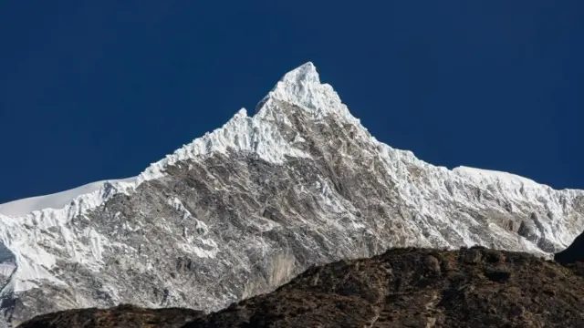 朗当利龙峰（Langtang Lirung）全景。白雪覆盖的山峰在晴朗的蓝天下清晰可见。