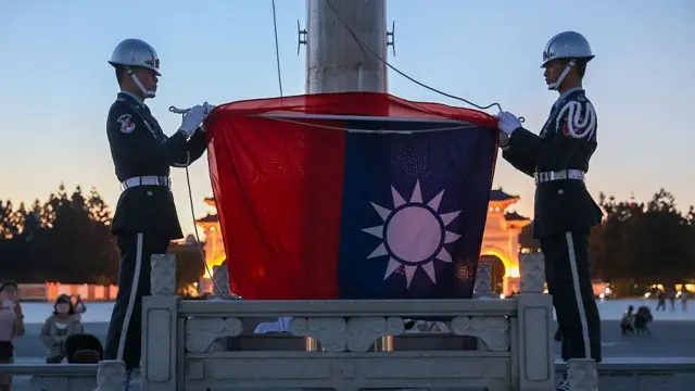 台北自由广场两名国军宪兵在傍晚降旗仪式后折叠中华民国国旗（23/9/2026）
