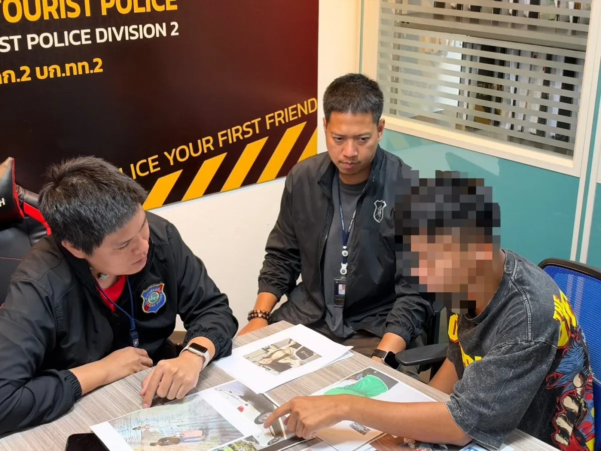 泰国旅游警察第二大队的警员向一名嫌犯问话