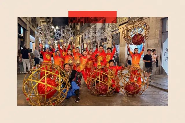 西班牙拉近中国关系引欧盟不满 德法联手欲设限 2 约15名身穿红色服装的表演者与他们巨大的银色和金色表演球道具合影。
