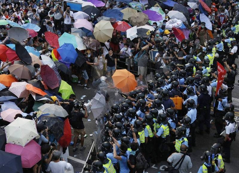 日本学者取得的机密文件显示,2014年雨伞运动期间广州军区政委曾主张准备军事行动 1 2014年9月28日,香港示威者撑起雨伞抵挡警方的胡椒喷雾(资料照片)