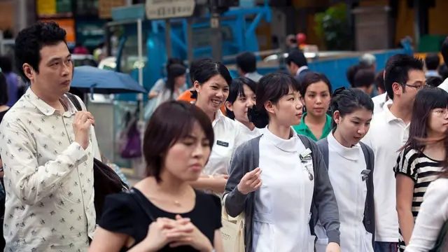 2010年9月16日，人们在香港繁忙路口穿梭。